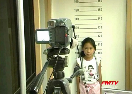 One young girl gets her picture taken for her 1st ID card.